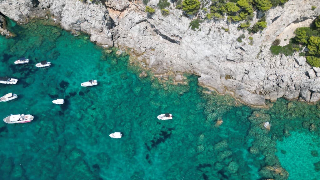 Speedboats anchored along a cliff coastline